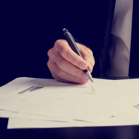 Close up of the hand of a man working on a presentation or performance analysis in square format.