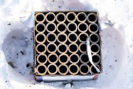 Used fireworks firecrackers lying on snow after exploding in celebration.の写真素材