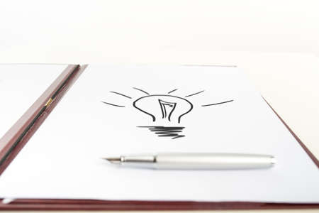 Speedball Pen on Top of White Paper with Conceptual Light Bulb Drawing. Over White Background.の写真素材