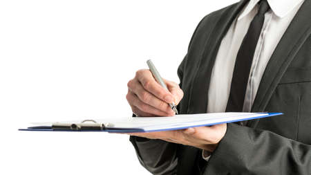 Side view of a businessman signing legal papers on a map with fountain pen, isolated over white background.の写真素材