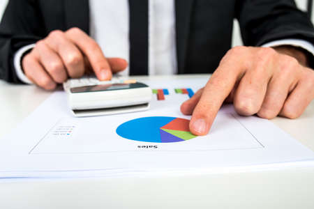 Financial adviser calculating numbers as he looks at the annual statistics.の写真素材