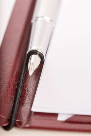Fountain pen on an open executive leather folder with white papers ready to take notes.の写真素材