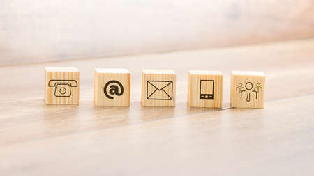 Close up Small Wooden Blocks with Assorted Contact Illustrations Arranged on Top of the Table.の写真素材