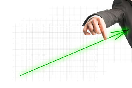 Hand of a businessman touching a green ascending arrow showing progress and growth on a virtual screen, with copy space.の写真素材