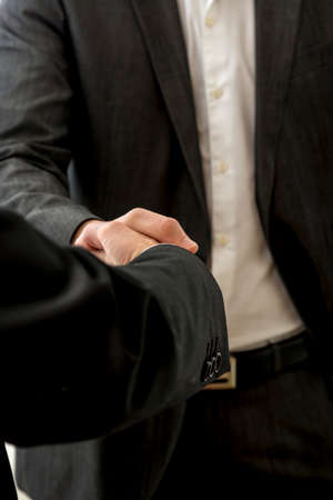 Closeup of two male business partners shaking hands. Conceptual of success, agreement and...