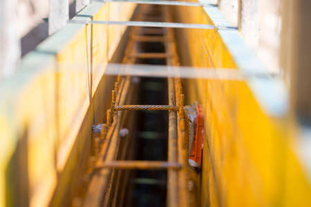 Closeup of metals rod supports inside wall on construction site, receding into distance.の写真素材