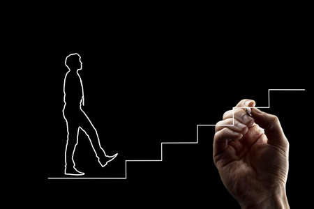 Shape of a man in tie walking up stairs. Hand drawing white lines over black background. Suitable for teamwork and personal growth concepts.の写真素材
