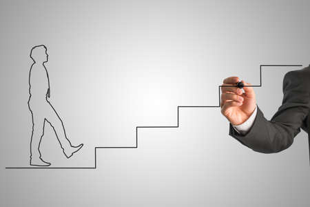 Shape of a businessman in tie walking up stairs. Hand drawing black lines over grey background. Conceptual of business career and solving problems and challenges.の写真素材