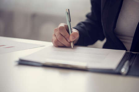Retro vintage style image of a businesswoman signing a contract or document on a map.