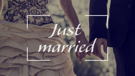Just married text over image of a bride and groom holding hands outdoors.の写真素材