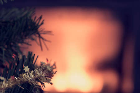 Glowing Christmas background with copy space and focus to small golden stars on the branch of a decorated Xmas tree, retro effect faded look.の写真素材