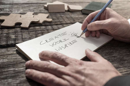 Conceptual close-up of the hands of a businessman writing an inspirational message and urge to work, create and inspire.の写真素材