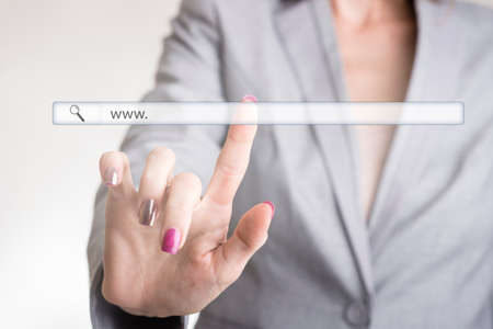 Female hand touching a website navigation bar with the text www and blank copy space on a transparent virtual screen.の写真素材