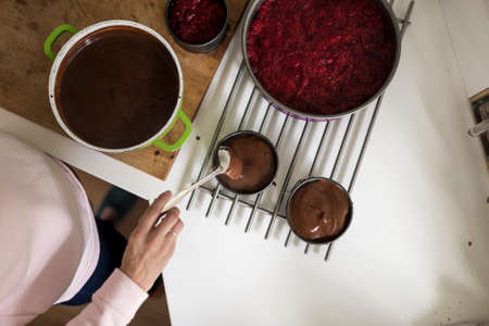 Top view of woman making a chocolate sauce or cake mix while baking in the kitchen.