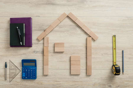 New build of a dream home planning and costing concept with a wood block outline of a house...