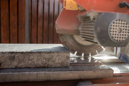 An angle grinder or circular saw with a concrete block in a close up side view.の写真素材