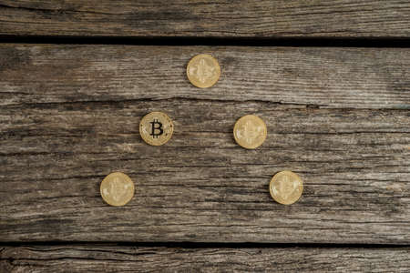 High angle view of golden Bitcoin coins over wooden table.の写真素材