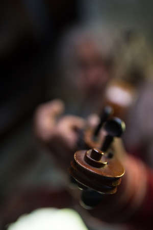 Man playing a violin with focus to scroll and pegs. Shallow dof.の写真素材