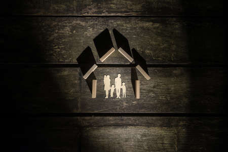 Top view of the shape of a house made of wooden blocks for a family with three children.の写真素材