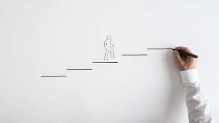 Paper silhouette cutout of a man and a businessman drawing steps on a white background.の写真素材