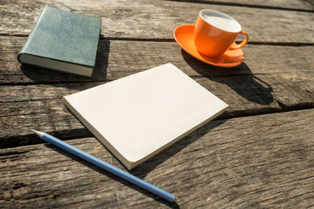 Coffee, pencil, notebook and blank piece of paper on textured wooden table.の写真素材