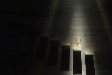 Conceptual business image of paper silhouette cutout of a man climbing the stairs.の写真素材