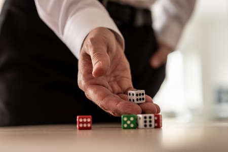 Business risk concept - businessman throwing dices on office desk.の写真素材