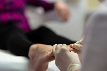 Closeup of professional beautician making a pedicure.
