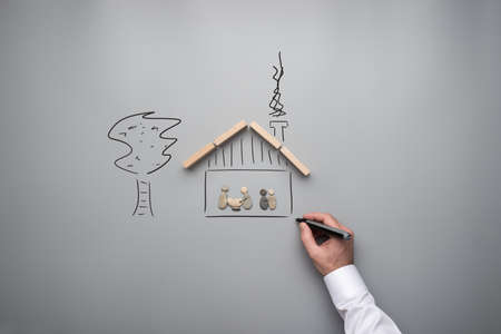 Family happiness concept - male hand drawing a family vision of a house and garden in a conceptual image.の写真素材