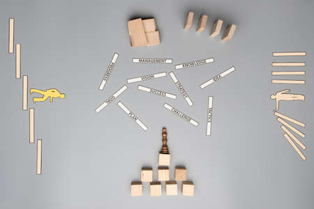 Business management and vision concept - wooden cubes and pegs placed over grey background, shape of...