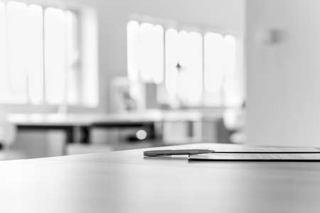 Monochrome image of application form and a pen lying on office desk.の写真素材