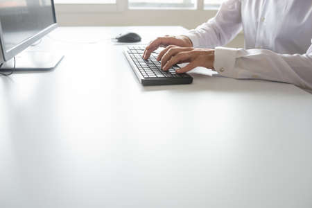 Programmer or student sitting at his office desk working using computer.の写真素材
