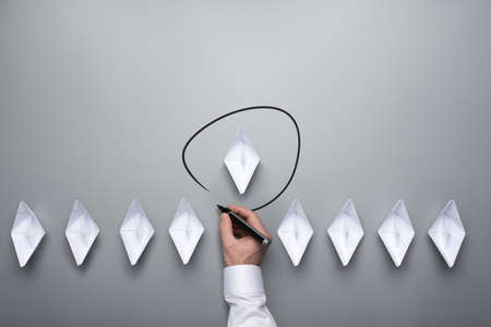 Conceptual image of business leadership and uniqueness with nine paper made boats, one of them as the leader, over grey background. With copy space.の写真素材