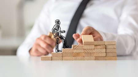 Silhouetted businessman walking up the steps made of wooden pegs by his mentor.