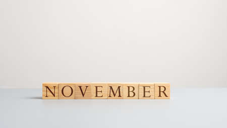 Word november on wooden cubes. Over white background.