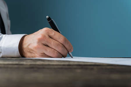 Low angle view of businessman or lawyer signing a document.