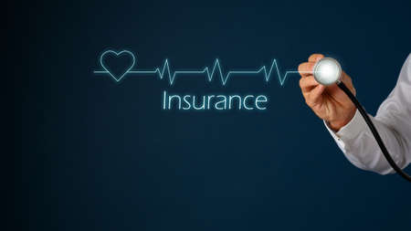 Glowing heart shape and cardiogram on virtual interface with male hand holding stethoscope next to it and Insurance sign under the frequency graph.の写真素材