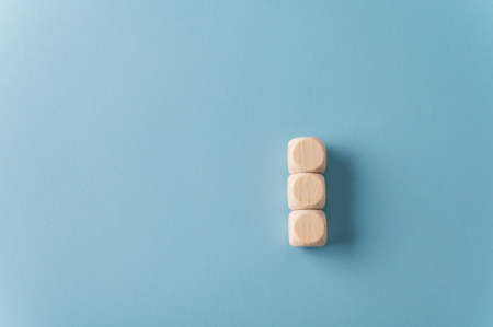 Three blank wooden dices stacked over light blue background. With plenty of copy space.の写真素材
