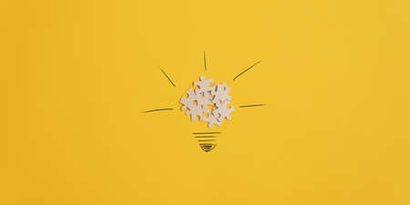 Conceptual image of idea and innovation - lightbulb made of puzzle pieces and hand drawn rays of light. Over yellow background with copy space. の写真素材