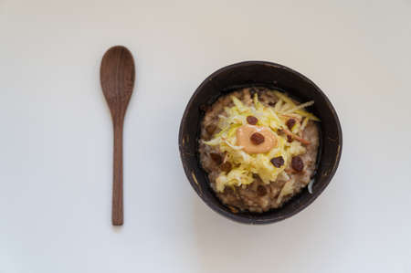 Top view of delicious and nutritious vegan breakfast oatmeal porridge topped with grated apple and...