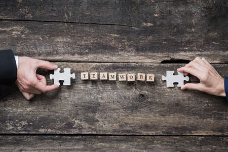 Business teamwork and partnership conceptual image - male and female hands holding puzzle pieces on...
