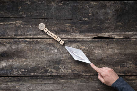 Business, education or personal goal and ambitions - male hand pushing paper made origami boat toward a conceptual target.の写真素材
