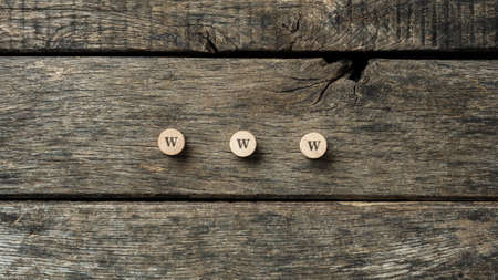 WWW sign spelled on three wooden cut circles placed on rustic wooden boards.の写真素材