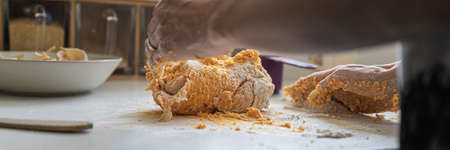 Wide low angle view image of a woman making pasta or gnocchi dough of sweet potato on kitchen...