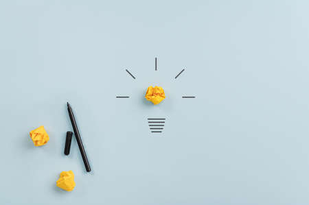 Brainstorming conceptual image - Light bulb made in combination of crinkled yellow it paper and hand drawing over light blue background.の写真素材