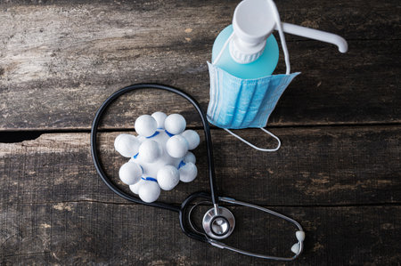Covid 19 conceptual image - stethoscope next to a medical protective mask and hand sanitizer.の写真素材