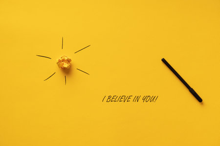 I believe in you sign spelled with black marker over yellow background next to the sun.の写真素材