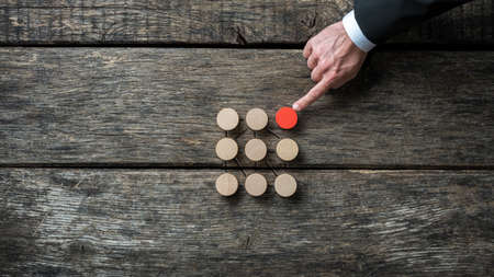 Social discrimation conceptual image - red wooden circle trying to fit in with a group of brown ones.の写真素材