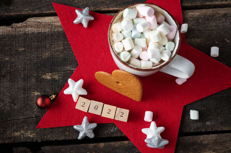 Top view of christmas and new year holiday still life - 2022 sign with delicious cup of hot chocolate with marshmallows and decorations.の写真素材