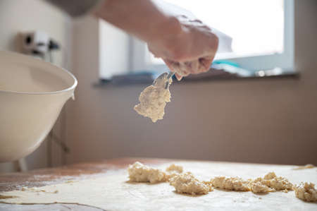 Low angle view of a female hand filling a rolled pastry dough with vegan cream cheese filling for a...